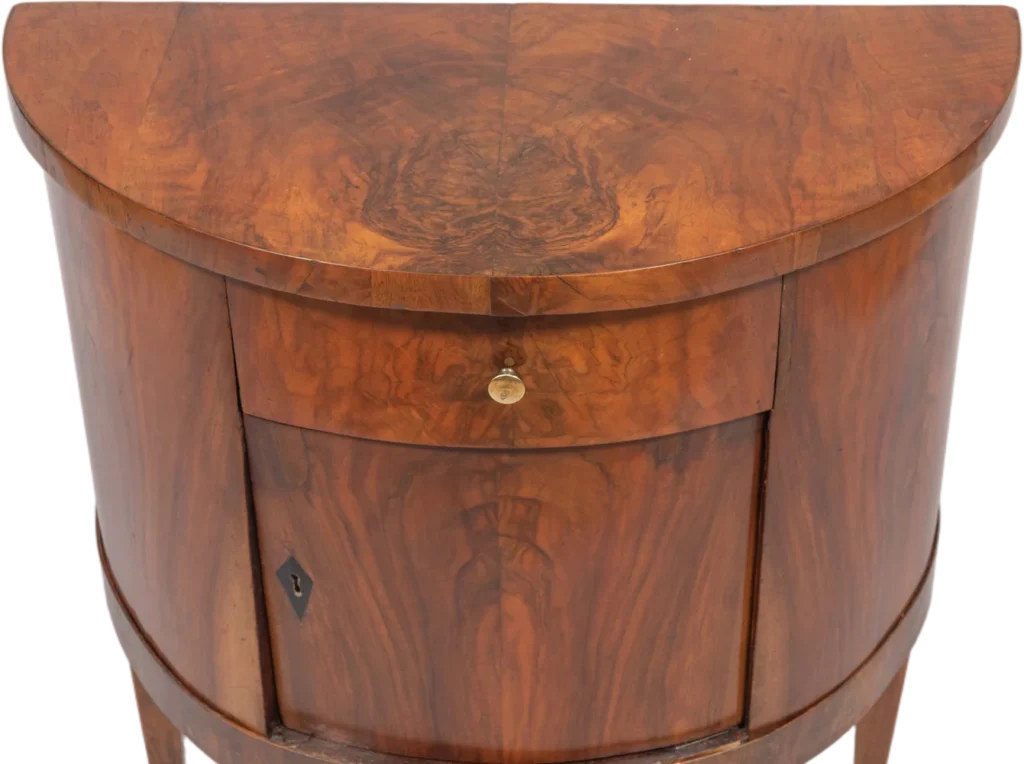 Zierlicher Demi- Lune- Halbschrank auf hohen, ausgestellten Beinen.